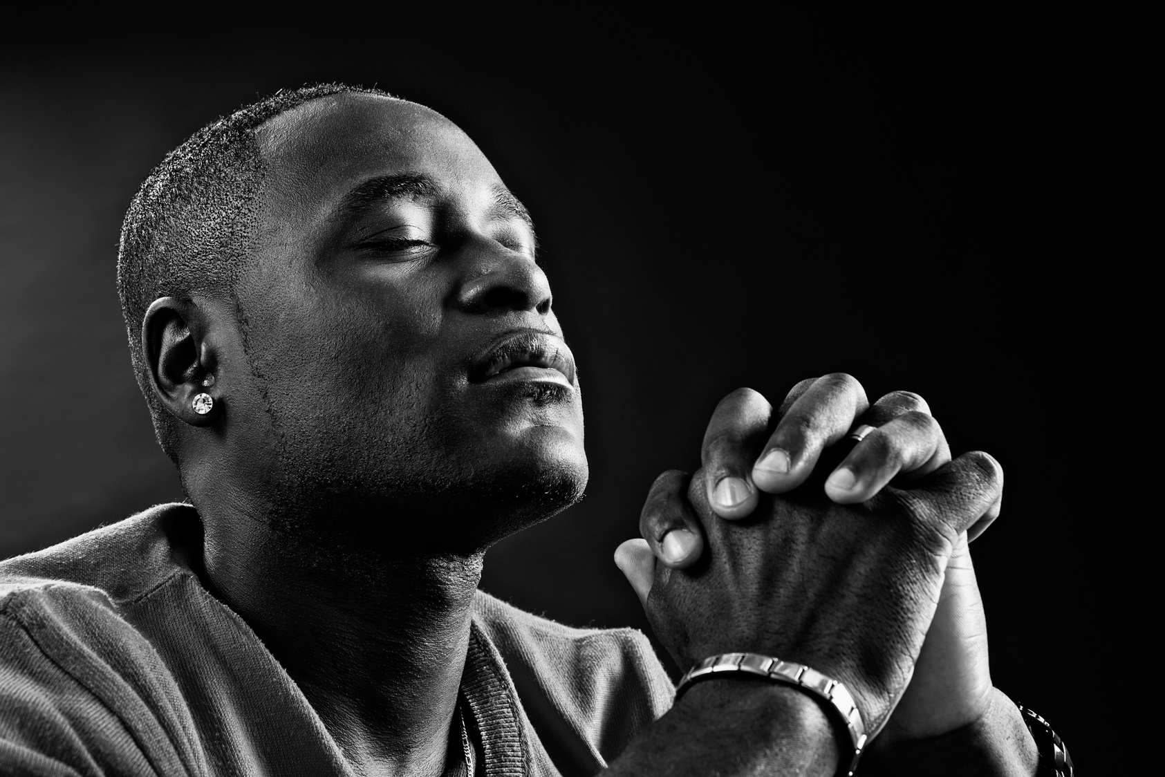 Devout African-American man praying fervently in black-and-white portrait